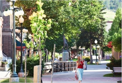 A woman walking on a tree-lined street in Helena.